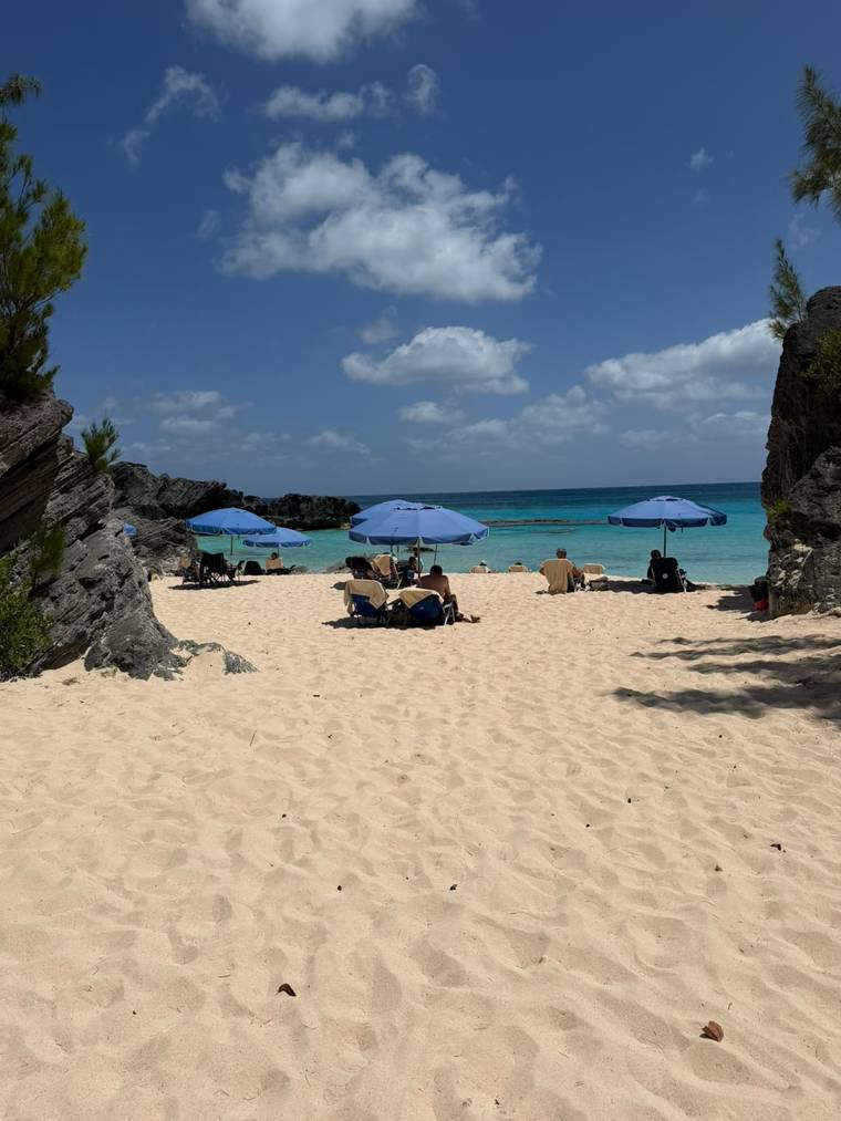 Blue umbrellas on the sand between rock outcrops at Chaplin Bay